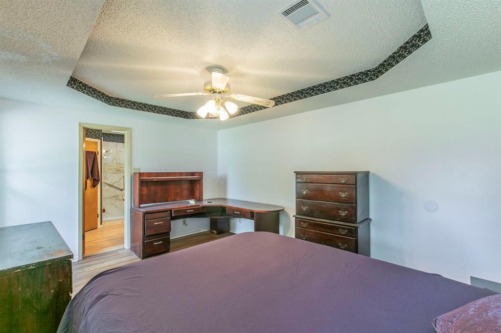 1936 Post Oak Drive Waco, TX 76705 - Photo 15 of 33 Bedroom with a textured ceiling, wood finished floors, ceiling fan, and connected bathroom
