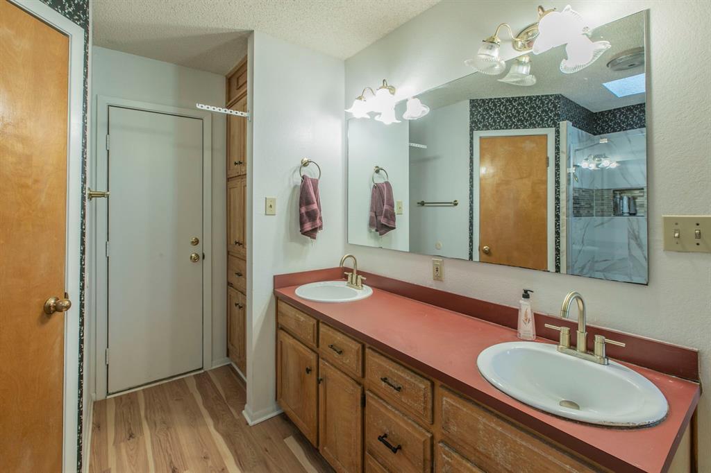 1936 Post Oak Drive Waco, TX 76705 - Photo 17 of 33 Bathroom with a shower stall, a textured ceiling, light wood finished floors, and double vanity