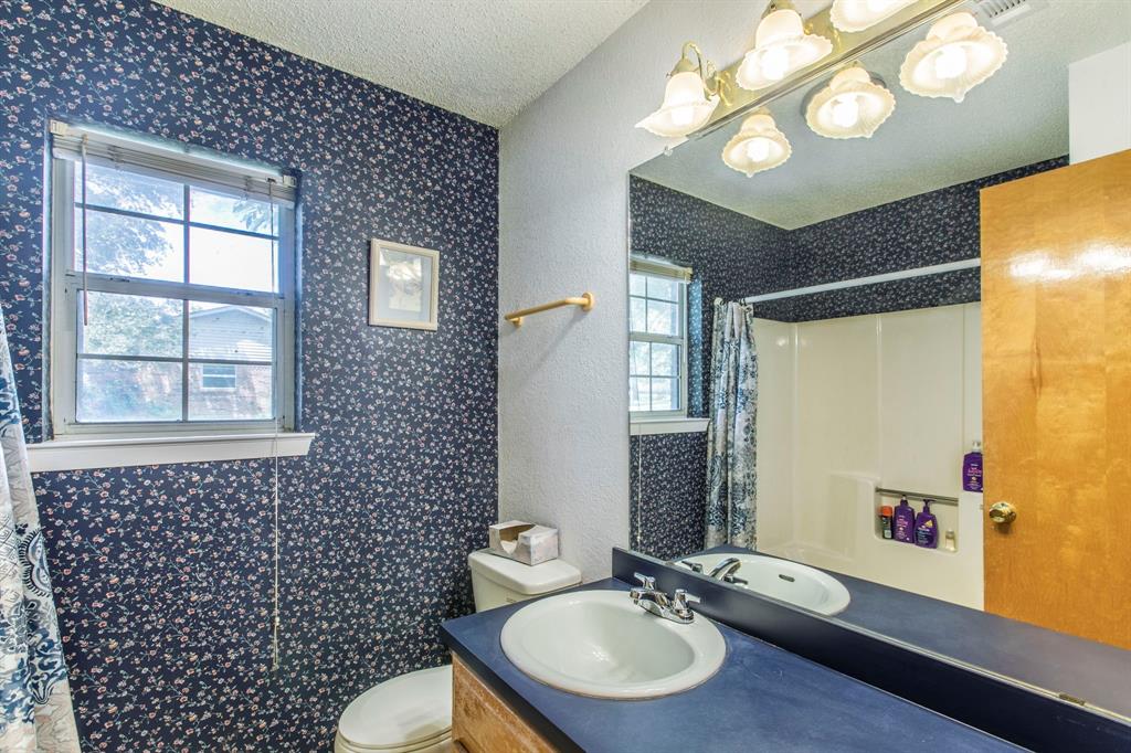 1936 Post Oak Drive Waco, TX 76705 - Photo 18 of 33 Full bath with vanity, a textured ceiling, wallpapered walls, and a shower with shower curtain