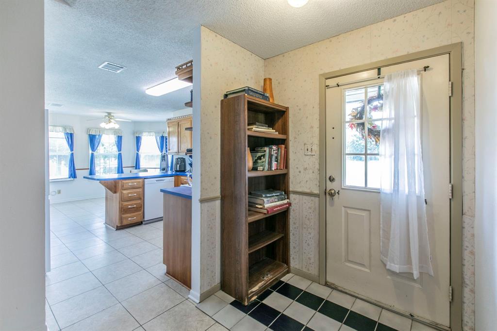 1936 Post Oak Drive Waco, TX 76705 - Photo 20 of 33 Doorway featuring wallpapered walls, plenty of natural light, a textured ceiling, tile patterned flooring, and a ceiling fan