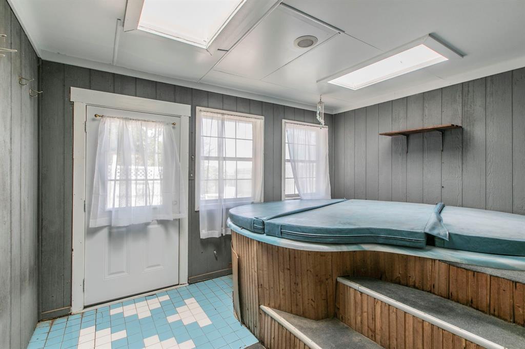 1936 Post Oak Drive Waco, TX 76705 - Photo 21 of 33 Miscellaneous room featuring a hot tub, wood walls, a skylight, and light tile patterned flooring