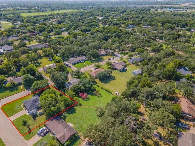 an aerial view of a residential houses with outdoor space and lake view