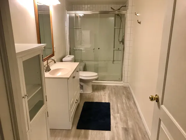 an empty room with a wooden floor and fan