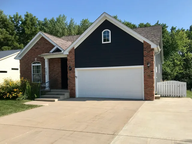 a front view of a house with a yard and trees