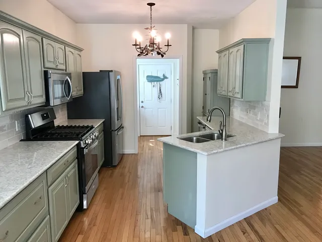 a kitchen with stainless steel appliances granite countertop a refrigerator stove and sink
