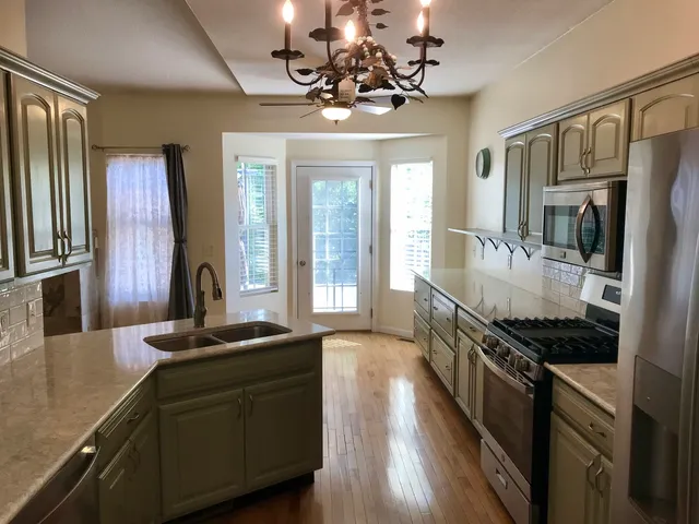 a kitchen with stainless steel appliances granite countertop a sink stove and refrigerator