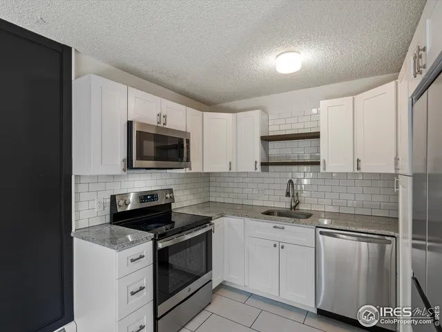 a kitchen with white cabinets stainless steel appliances and sink