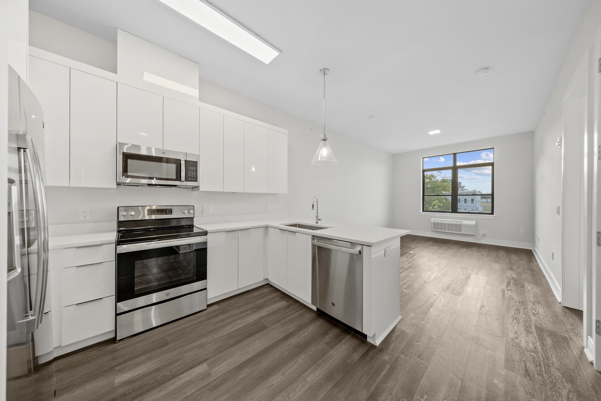a kitchen with stainless steel appliances granite countertop a stove a sink and a microwave