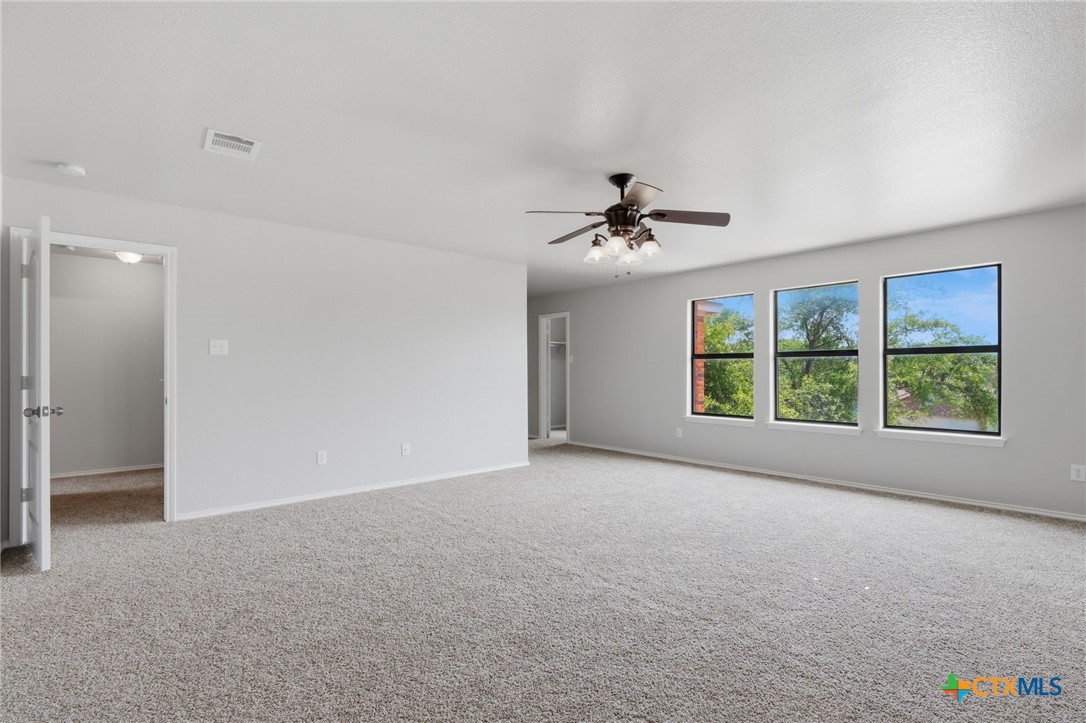 8716 Starview Street Temple, TX 76502 - Photo 22 of 36 Versatile carpeted room featuring a ceiling fan and abundant natural light.