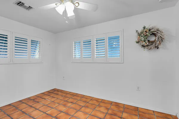 a view of an empty room and chandelier fan