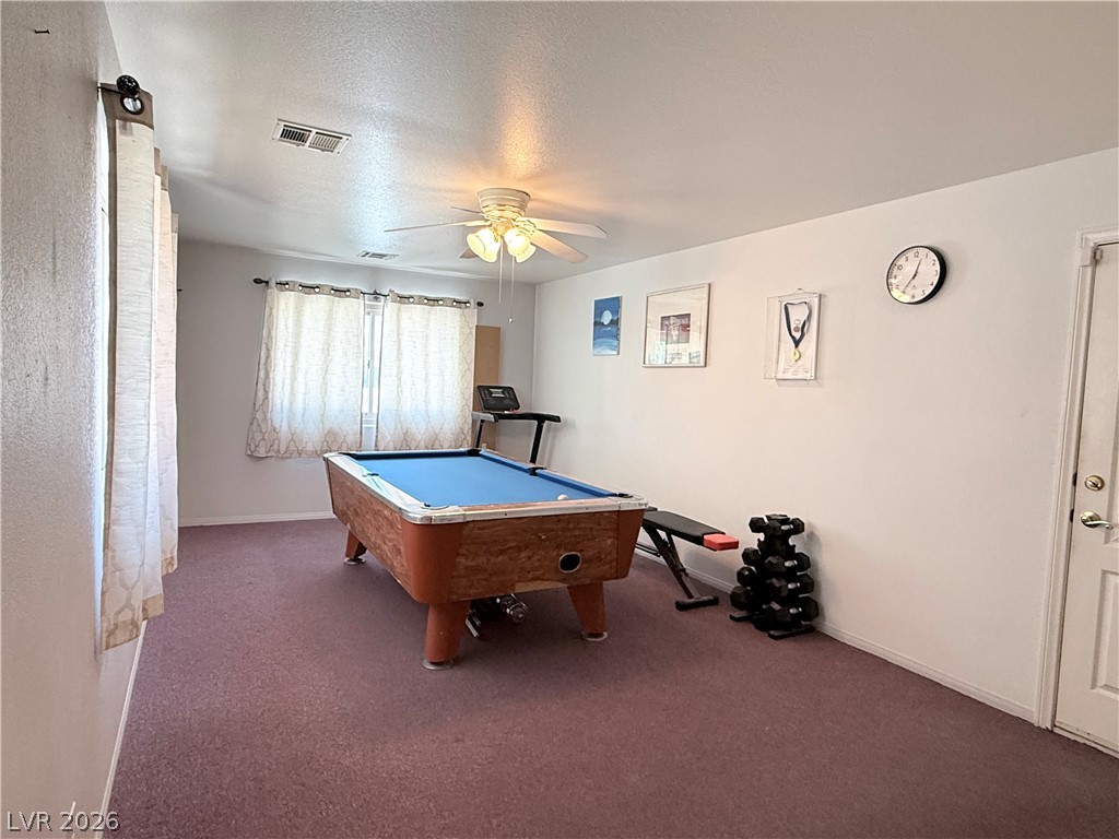 1220 East Gamebird Road Pahrump, NV 89048 - Photo 10 of 49 A vibrant game room offers endless entertainment and a dedicated fitness zone.
