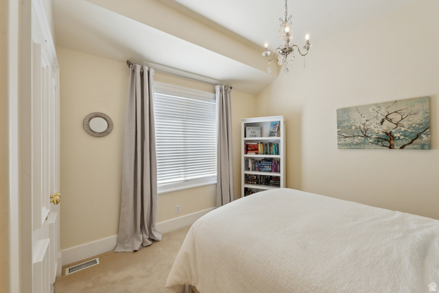 1714 Ridge Point Drive Bountiful, UT 84010 - Photo 50 of 132 Vaulted ceiling with chandelier, window with blinds, paneled door with brass hardware, built-in shelving, and carpeted flooring