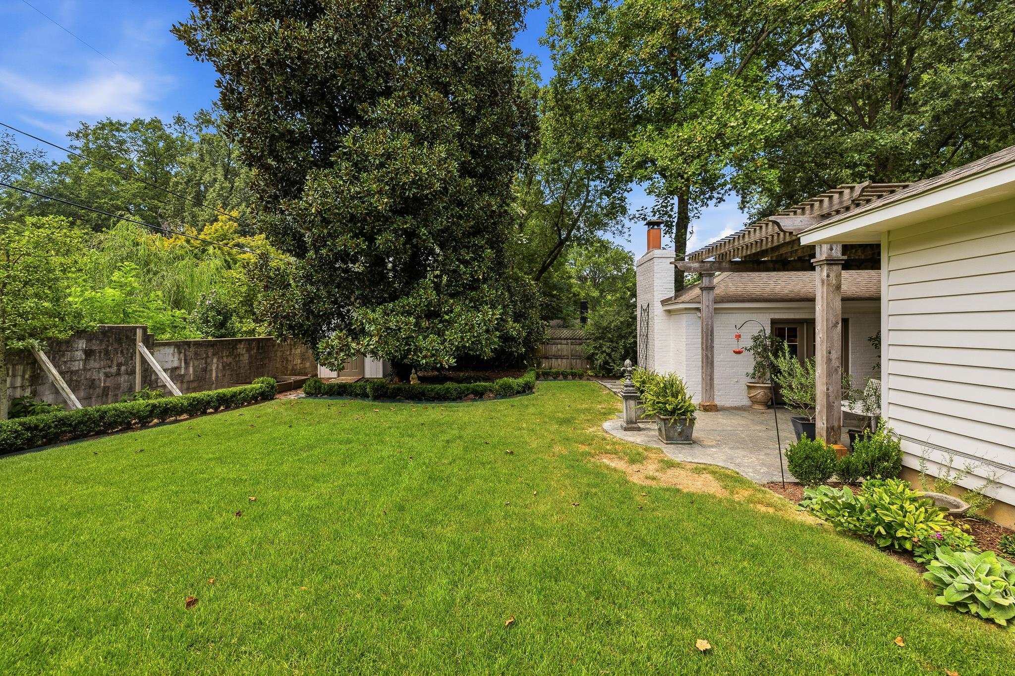 253 Ridgefield Road Memphis, TN 38111 - Photo 32 of 32 Expansive lawn with mature trees, bordered by a stone wall