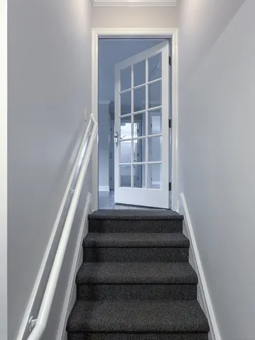 a view of staircase with white walls and windows