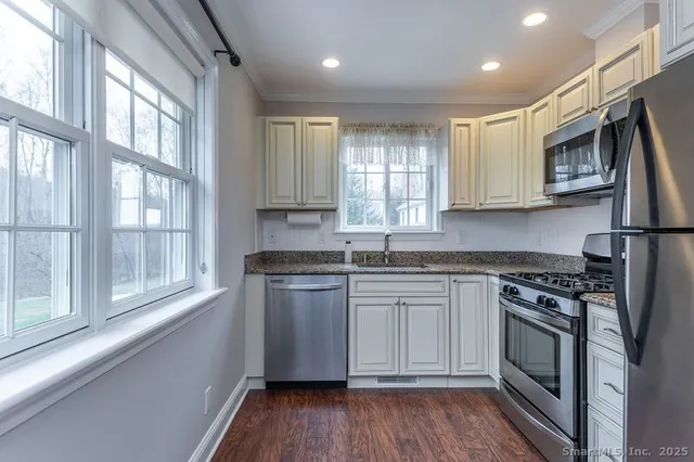 a kitchen with stainless steel appliances granite countertop a stove a sink and a microwave