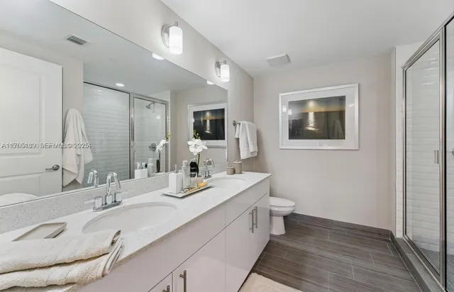 a bathroom with a double vanity sink mirror and toilet