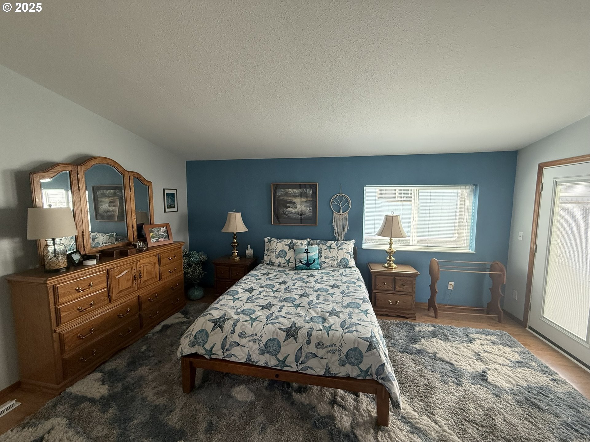 100 River Bend Road, Unit 17 Reedsport, OR 97467 - Photo 20 of 29 a bedroom with a large bed and wooden floor