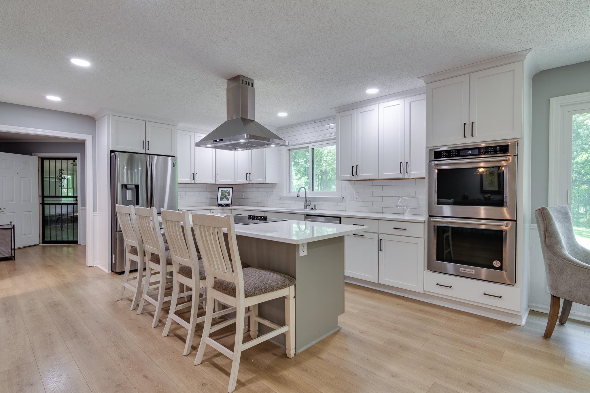 462 Woodbridge Road Somerville, TN 38068 - Photo 2 of 30 Kitchen with island range hood, appliances with stainless steel finishes, a kitchen island, light wood-style flooring, and backsplash
