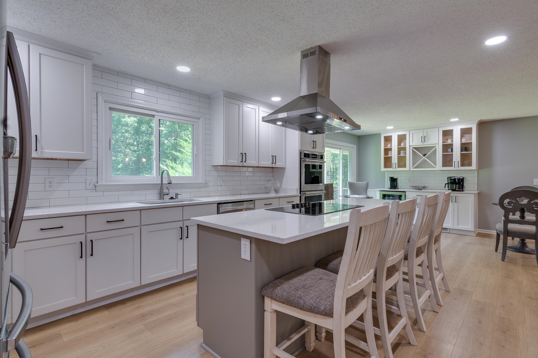462 Woodbridge Road Somerville, TN 38068 - Photo 3 of 30 Kitchen with island range hood, tasteful backsplash, light wood-style flooring, stainless steel appliances, and a center island