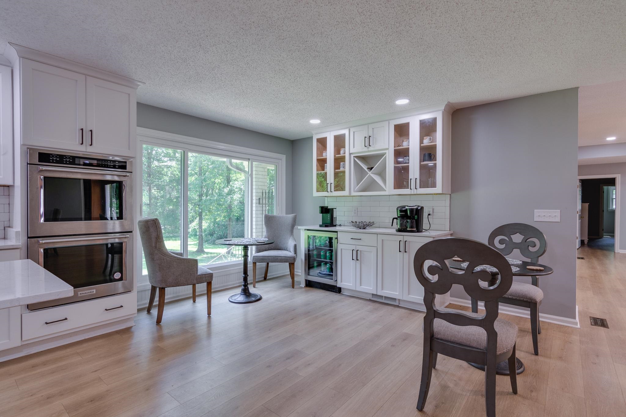 462 Woodbridge Road Somerville, TN 38068 - Photo 6 of 30 Indoor bar featuring double oven, wine cooler, decorative backsplash, light wood-style flooring, and a textured ceiling
