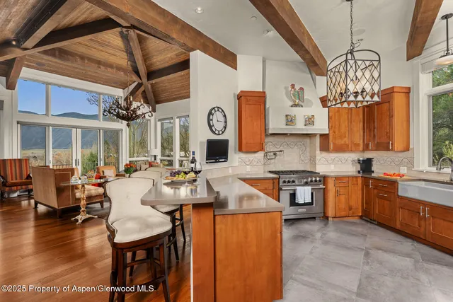 a large kitchen with a table chairs stove and wooden floor