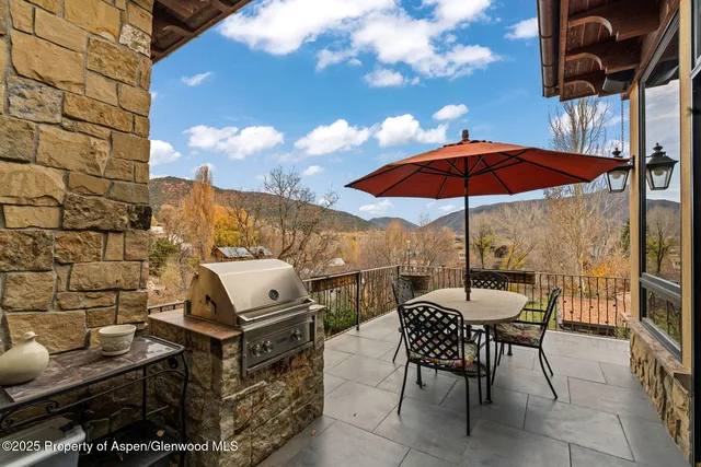 a view of a roof deck with table and chairs