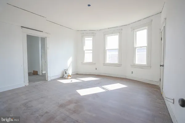 an empty room with windows and closet