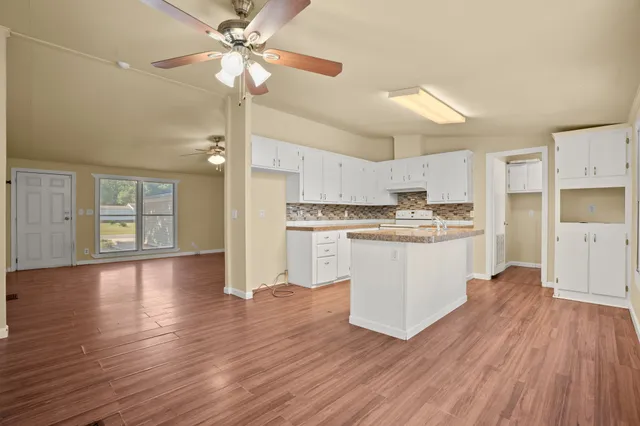 a view of kitchen with granite countertop cabinets and refrigerator