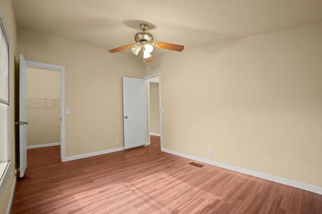 a view of an empty room with wooden floor