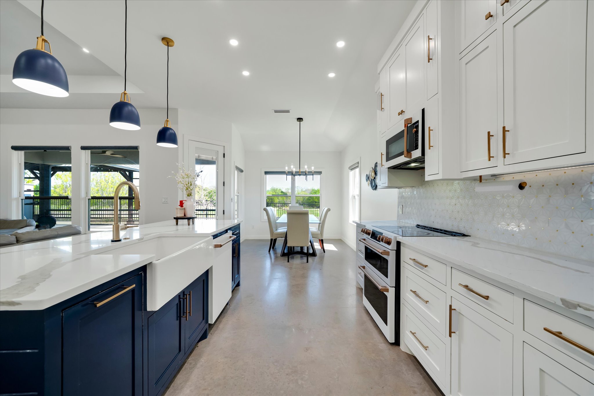1611 Johnson Street Marble Falls, TX 78654 - Photo 11 of 40 a kitchen with kitchen island a stove a sink a center island and windows