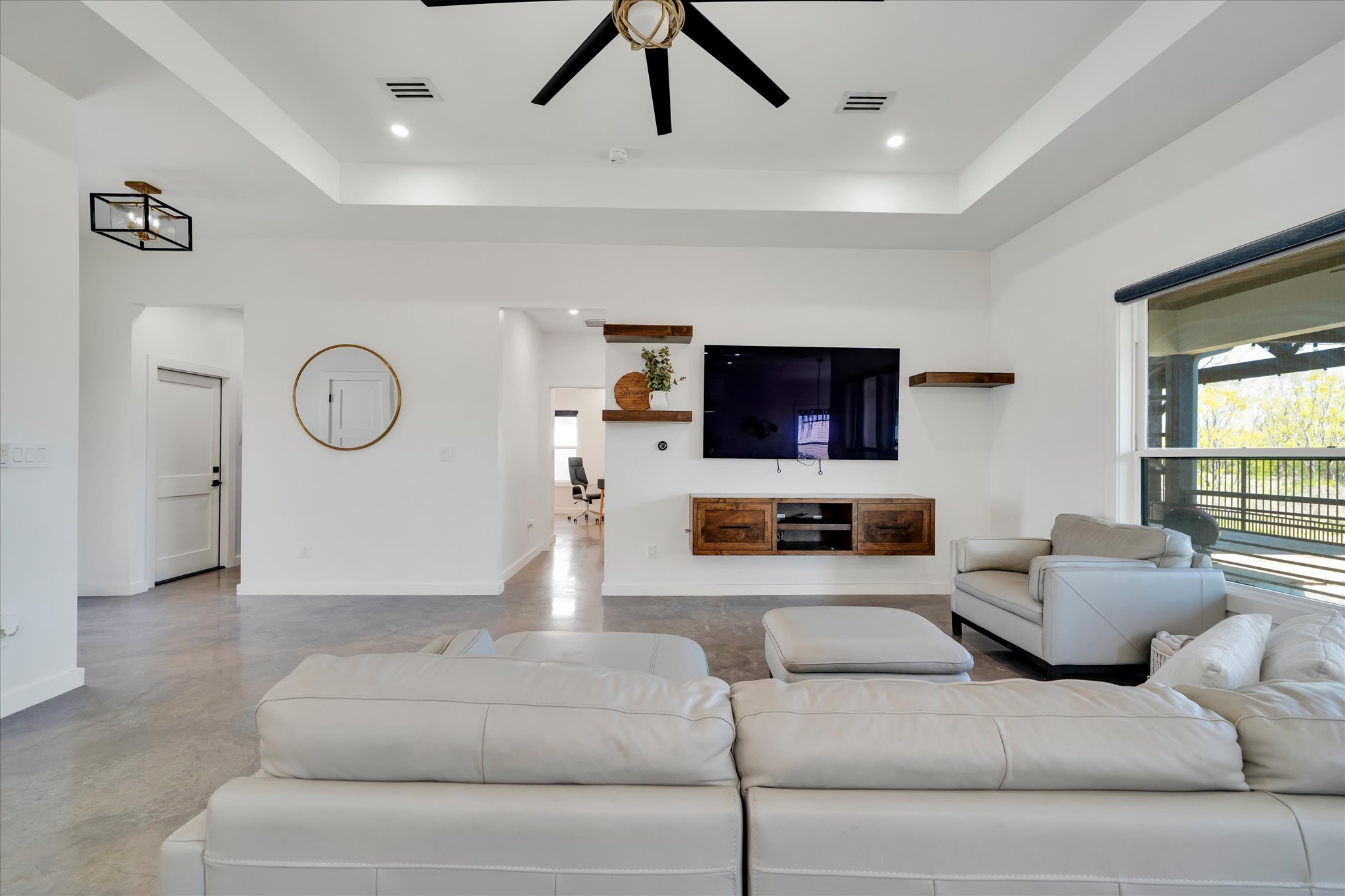 1611 Johnson Street Marble Falls, TX 78654 - Photo 6 of 40 a living room with furniture a ceiling fan and a flat screen tv