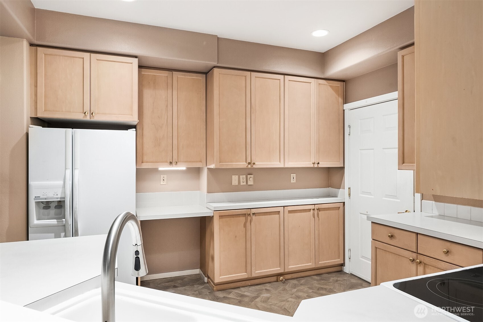 4325 Northeast 5th Court, Unit C101 Renton, WA 98059 - Photo 7 of 17 a kitchen with granite countertop a stove a sink and white cabinets with wooden floor