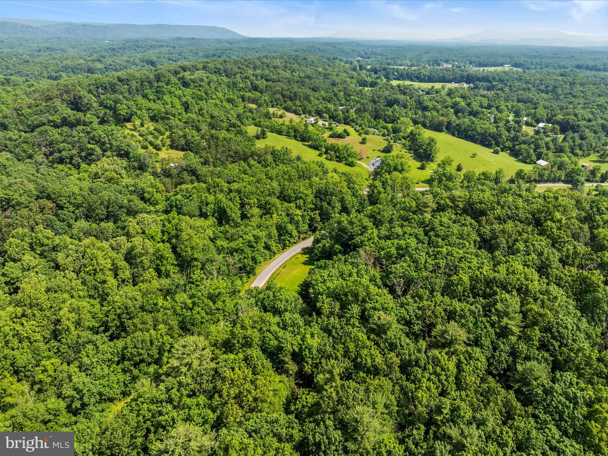 2732 Crossroad School Road Hedgesville, WV 25427 - Photo 20 of 41 a view of a field of a building with a lush green forest