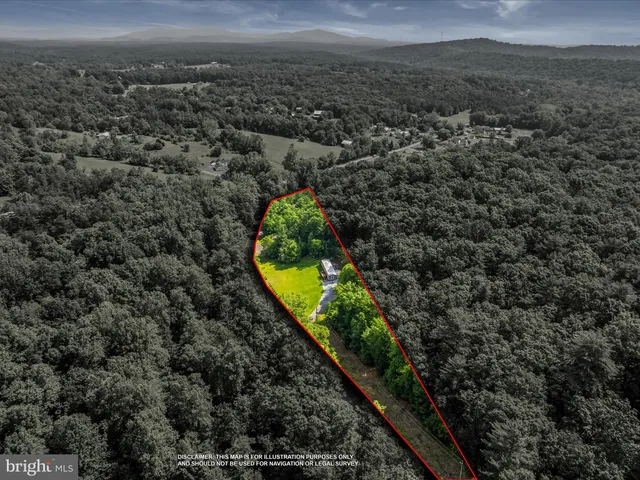 an aerial view of house with yard and mountain view in back