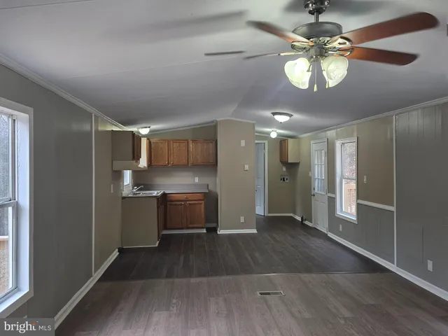 a view of a kitchen with a sink wooden floor and cabinets