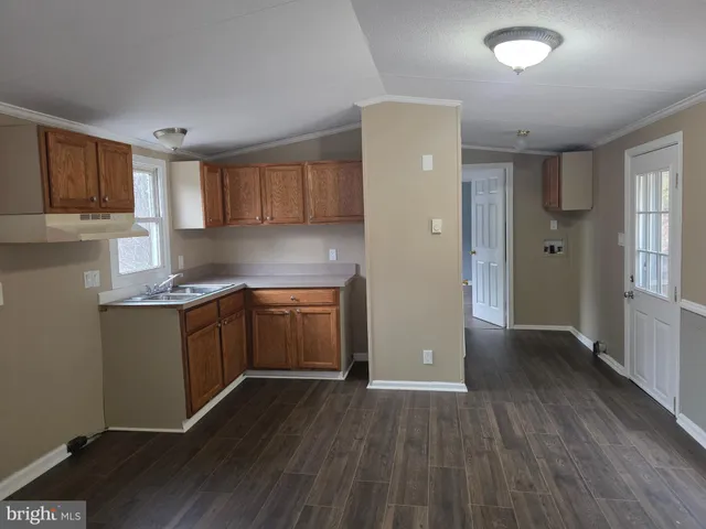 a kitchen with granite countertop a refrigerator and a sink