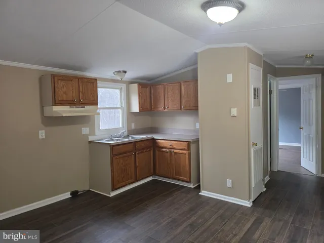 a kitchen with granite countertop wooden floors and white stainless steel appliances