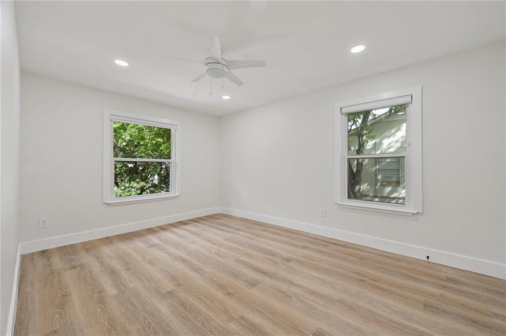 3511 Alpine Circle, Unit 1 Austin, TX 78704 - Photo 14 of 22 an empty room with wooden floor a ceiling fan and windows