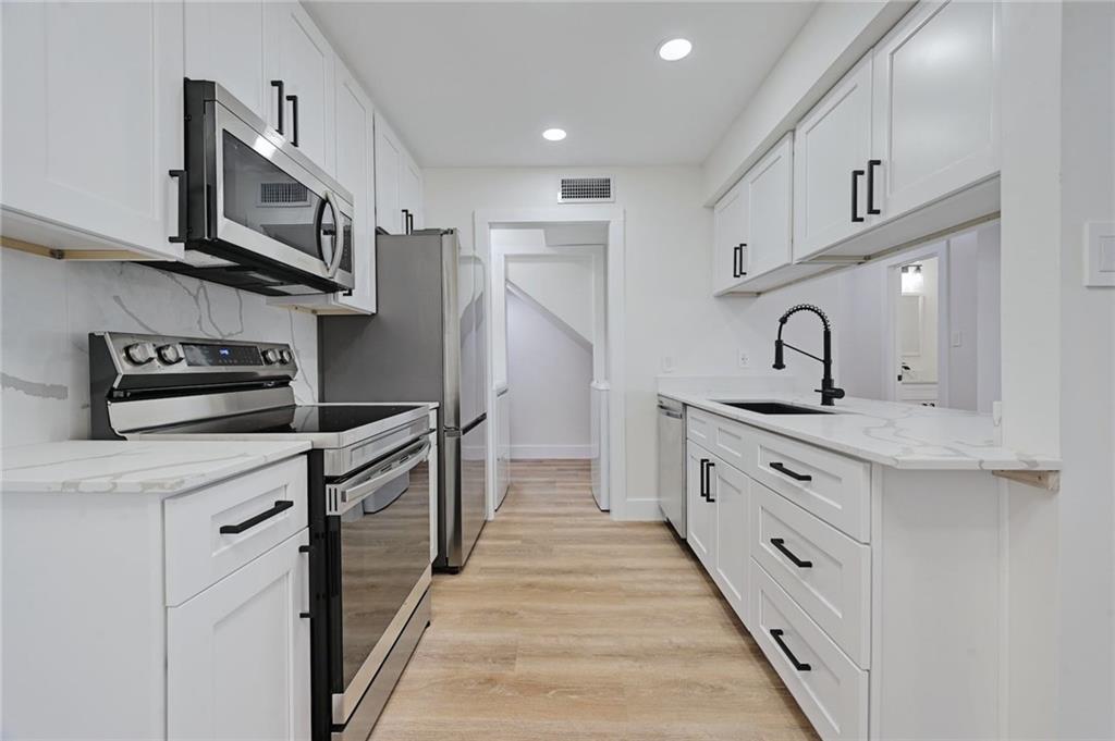 3511 Alpine Circle, Unit 1 Austin, TX 78704 - Photo 9 of 22 a kitchen with stainless steel appliances a sink stove microwave and cabinets