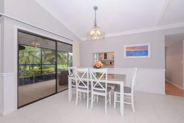 a dining room with furniture a chandelier and window
