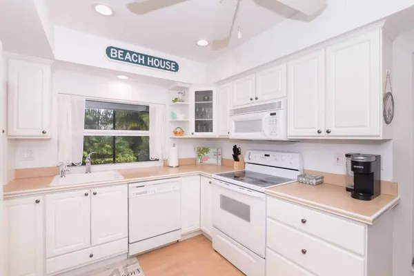 a kitchen with white cabinets and sink