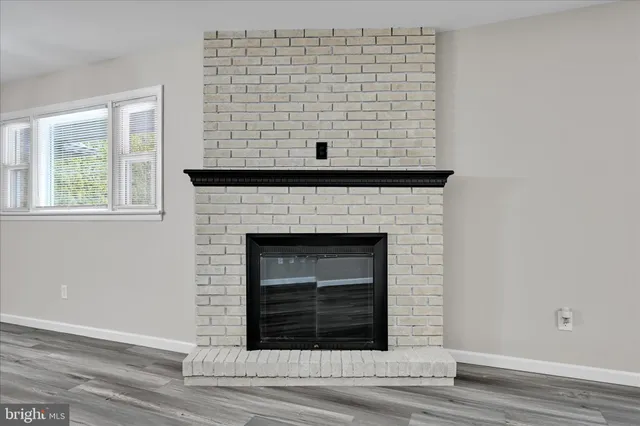 a view of a livingroom with a fireplace and window