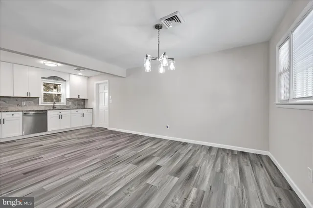 a view of a kitchen with wooden floor and a window