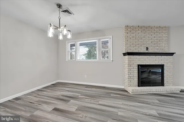 a view of a livingroom with a ceiling fan fireplace and a wooden floor