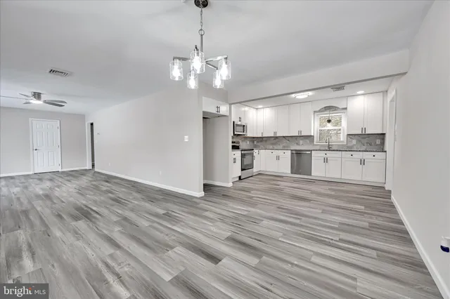 a view of a kitchen with a sink dishwasher a refrigerator and wooden floor
