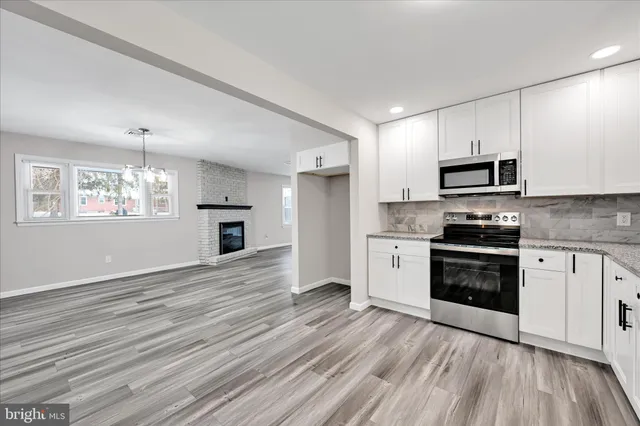 a kitchen with granite countertop a stove top oven sink and cabinets
