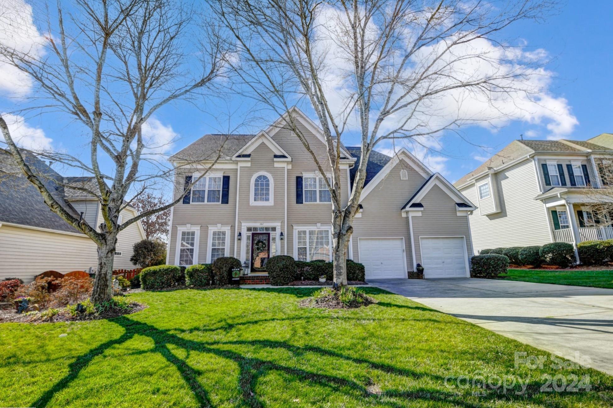 a front view of a house with yard and green space
