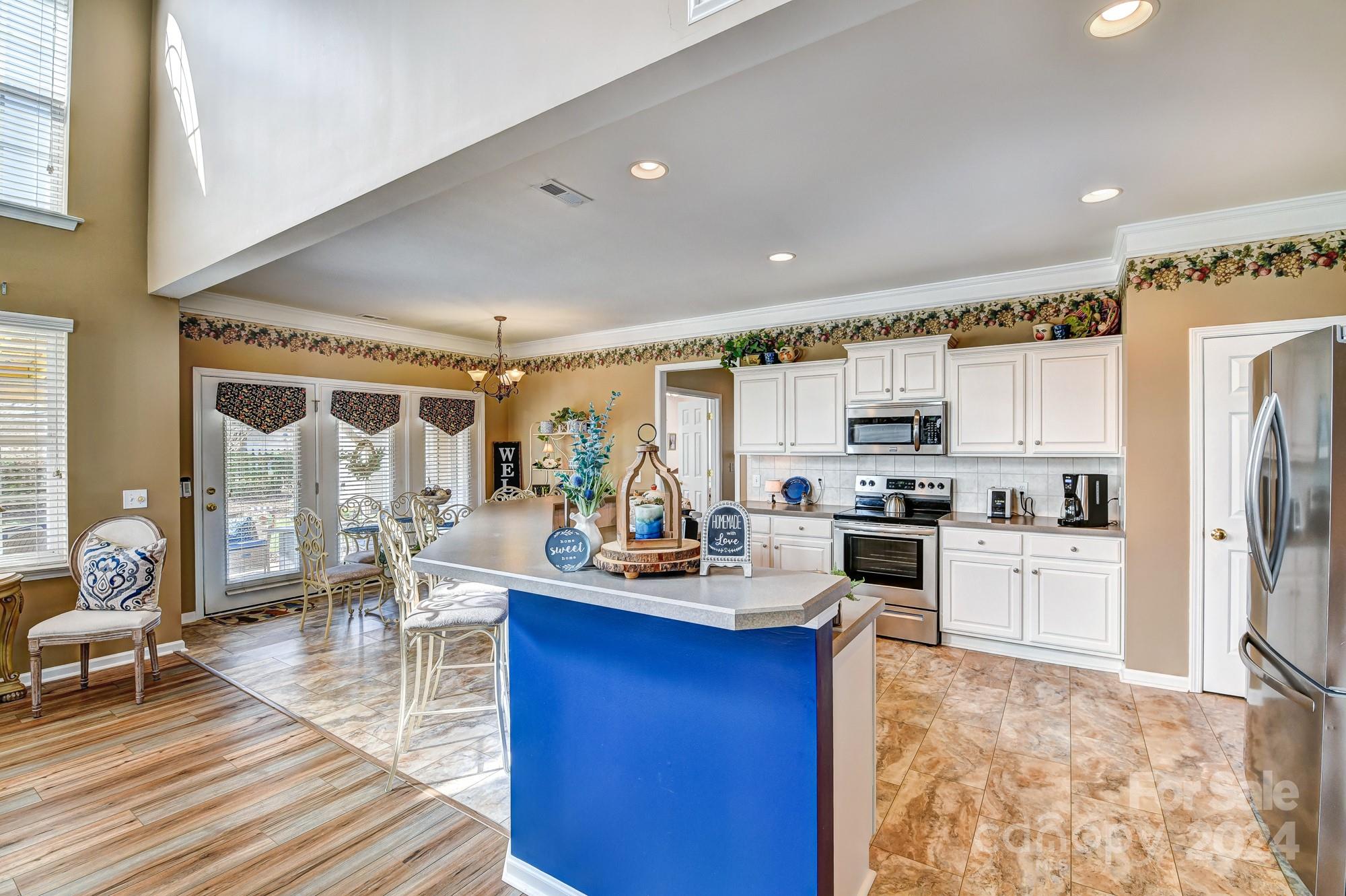 182 Harris Farm Road Mooresville, NC 28115 - Photo 9 of 46 a kitchen with stainless steel appliances kitchen island granite countertop a refrigerator a stove top oven a sink dishwasher and white cabinets with wooden floor