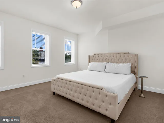 a large bed sitting in a bedroom next to a window