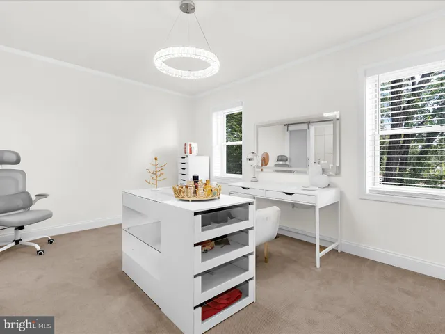 a room with a desk chairs and chandelier